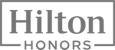 The image displays the Hilton Honors logo, featuring the brand name with a simple, bold font within a rectangular frame.